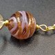 Złocisty widelec do włosów z beżowymi koralikami lampwork.