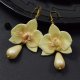 Kolczyki orchidee ze szklaną kroplą w delikatnym odcieniu złota