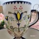 Kubek ceramiczny folkowy Bell dekoracja Tulipan kaszubska ceramika ręcznie zdobiona kubek tulipan wzór kaszubski rękodzieło malowany i stempelkowany