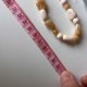 Naszyjnik w stylu boho z beżowych i brązowych koralików o różnych kształtach.