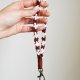 Makramowy breloczek wristlet z kwiatuszkami | Brelok ze sznurka bordo