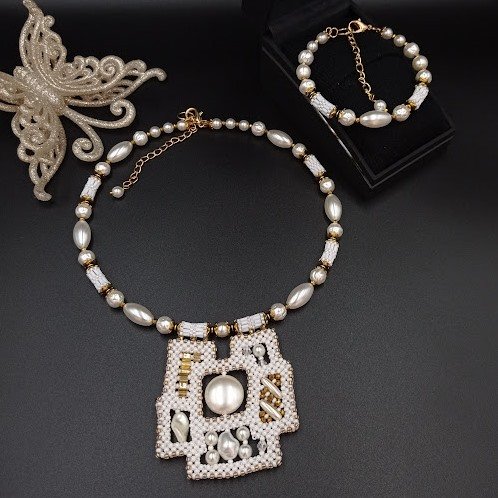 Komplet biżuterii naszyjnik-choker z zawieszką i bransoletką na drucie pamięciowym z pereł akrylowych.