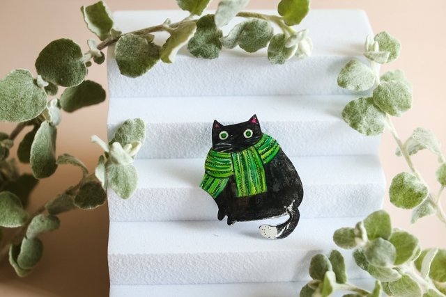 Czarny kot w zielonym szalu