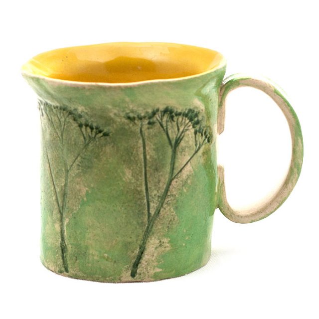 Zielony kubek ze słonecznym wnętrzem na zieloną herbatę
