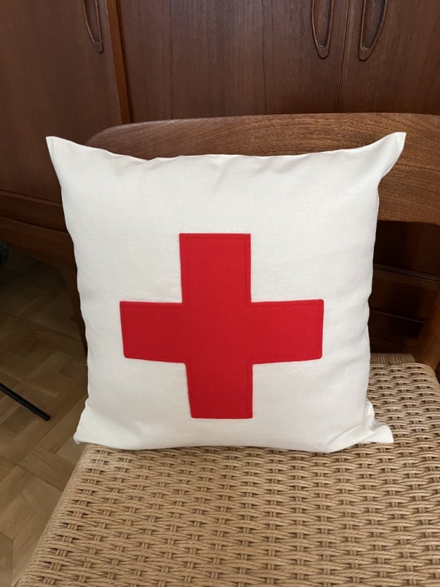 Poduszka z czerwonym plusem