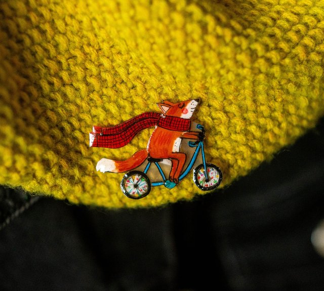 Mała przypinka z liskiem Andrzejem na rowerze