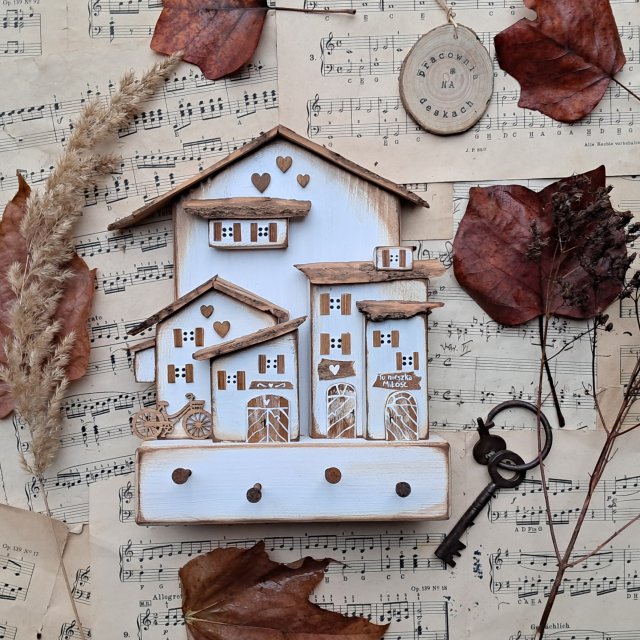 Rustykalny wieszak z  białym miasteczkiem on 2