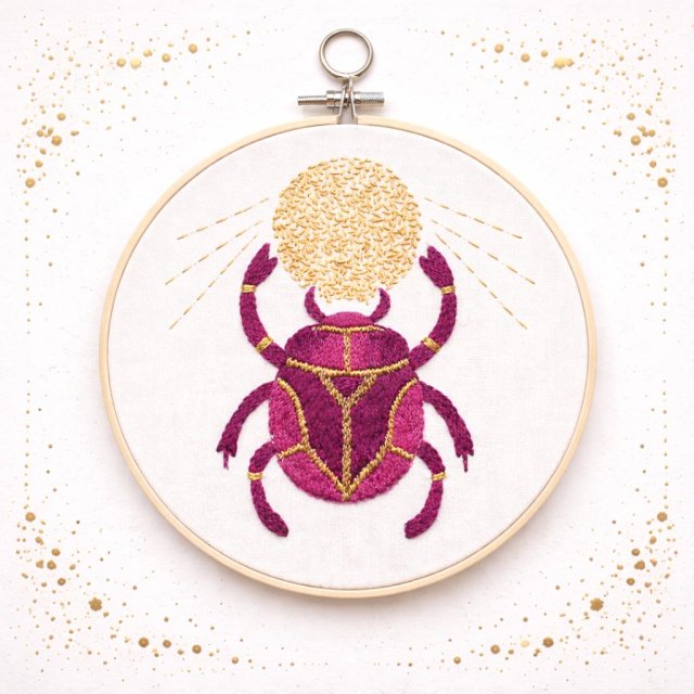 Skarabeusz w tamborku, talizman odrodzenia i twórczości.