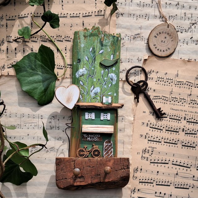 Rustykalny wieszak z domkiem wśród zieleni