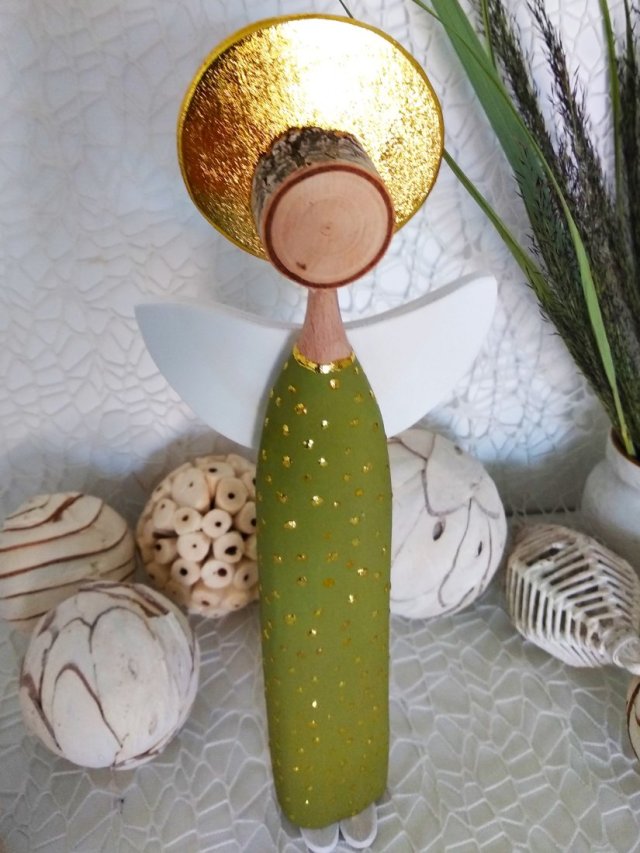 Anioł w zielonej sukience ze złotymi zdobieniami.