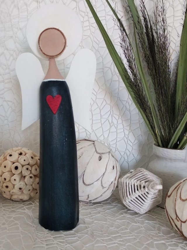 Anioł bukowy z czerwonym sercem.