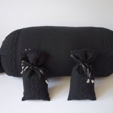 Czarna poduszka dekoracyjna - wałek z dwiema sakiewkami.