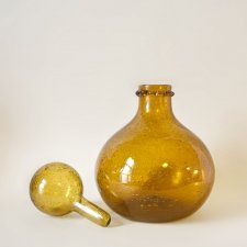 Pękata, żółta karafka z korkiem