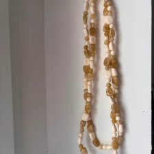 Naszyjnik w stylu boho z beżowych i brązowych koralików o różnych kształtach.