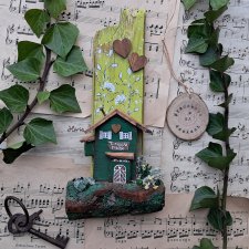 Rustykalny wieszak z domkiem wśród zieleni