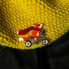 Mała przypinka z liskiem Andrzejem na rowerze