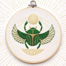 Skarabeusz w tamborku, talizman odrodzenia i twórczości.