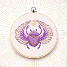 Skarabeusz w tamborku, talizman odrodzenia i twórczości.