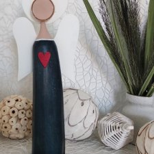 Anioł bukowy z czerwonym sercem.